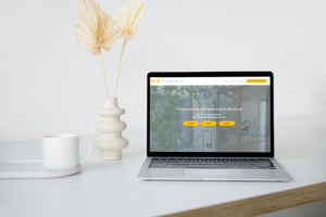 ein aufgeklappter Laptop steht auf einem hellen Tisch